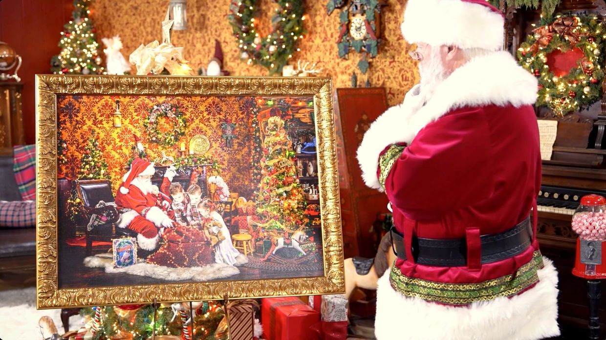 A finished fine-art wall piece of Santa and children, on a gilded easel in the workshop