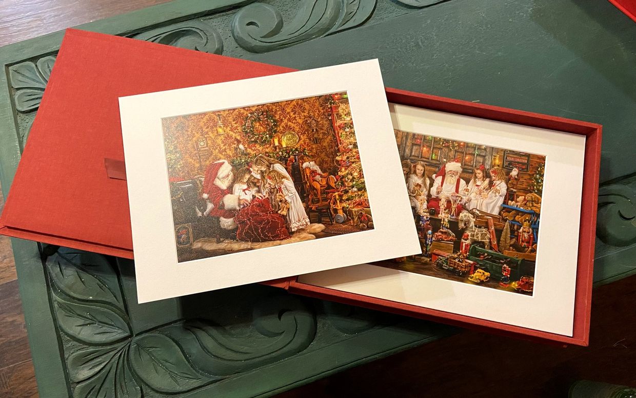 A red folio presentation box holding two matted fine-art prints of the visit